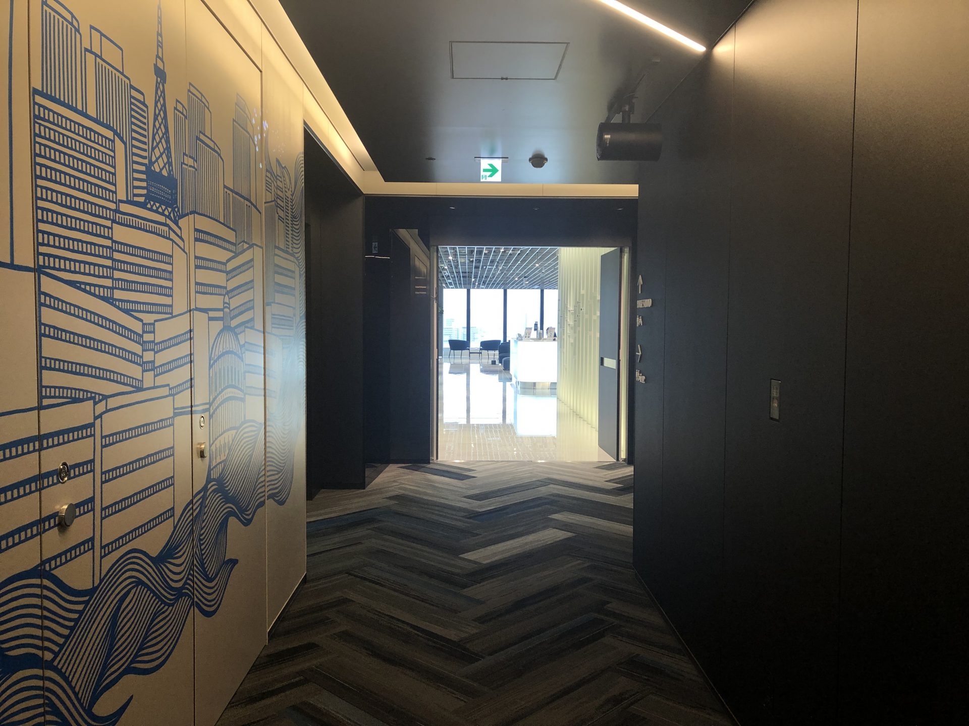 ビジネスエアポート竹芝 8Fエレベーター正面の案内表示通り、青いイラストの壁沿いに廊下を進み突き当り正面が受付
